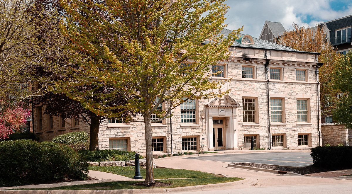 The Paulson Wealth office entrance on a tree-lined street